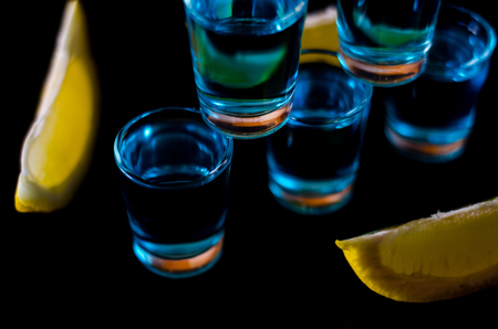 Popular drink shot kamikaze based on vodka, blue curacao and lemon juice, refreshing drink, party nightの写真素材