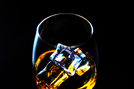 Scottish whisky in a glass with ice cubes, golden color whiskey, exclusive drinkの写真素材