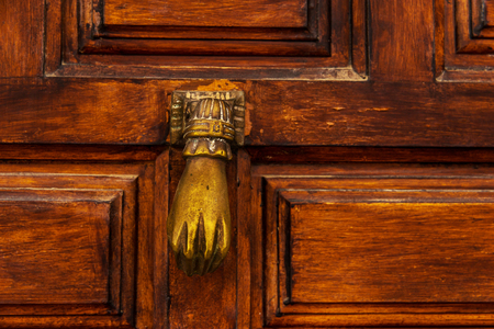 Door with brass knocker in the shape of a hand,  beautiful entrance to the house, vintage decorationの写真素材