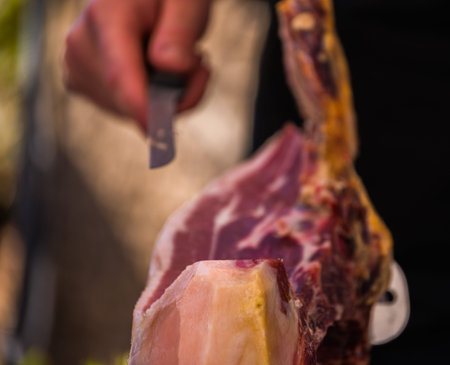 Professional butcher slicing jamon serrano, traditional Spanish ham, meatの写真素材