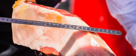 Professional butcher slicing jamon serrano, traditional Spanish ham, meatの写真素材