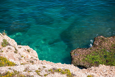 High cliff above the sea, summer sea background, many splashing waves and stone, sunny dayの写真素材