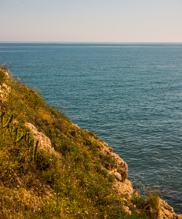 High cliff above the sea, summer sea background, many splashing waves and stone, sunny dayの写真素材