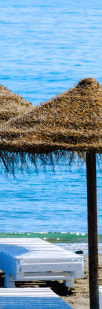 Beautiful sandy beach with umbrellas and blue sea, vacation conceptの写真素材