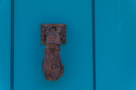 Door with brass knocker in the shape of a hand,  beautiful entrance to the house, vintage decorationの写真素材