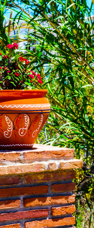Beautiful ceramic flower pot on a pedestal with flowers, decoration of urban space,outdoor decoration, decor streetの写真素材