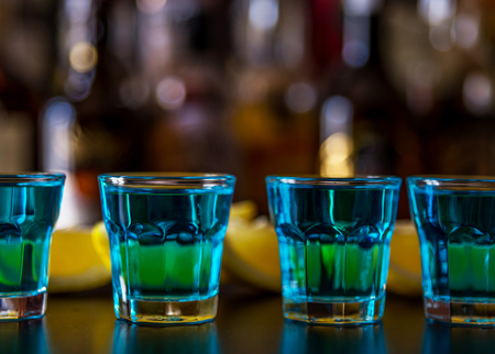 Popular blue drink shot kamikaze on the background of the bar with bottles, a refreshing drink, party nightの写真素材