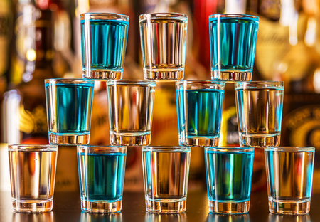 Popular blue drink shot kamikaze on the background of the bar with bottles, a refreshing drink, party nightの写真素材
