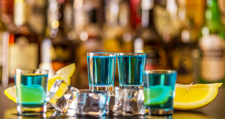 Popular blue drink shot kamikaze on the background of the bar with bottles, a refreshing drink, party nightの写真素材