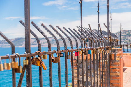 Rusty padlock attached to a balustrade by the sea, a traditional way of showing love, relationshipの写真素材