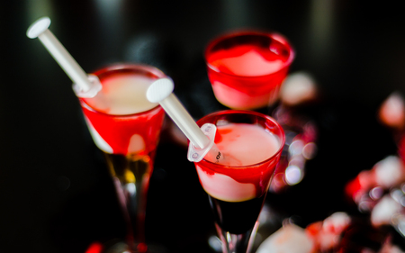 Creepy Halloween party cocktails with syringes of grenadine syrup as blood, shot drinks at party, scary barの写真素材