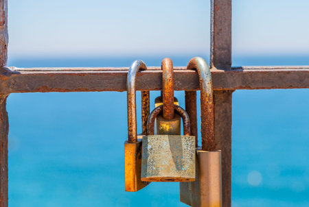 Rusty padlock attached to a balustrade by the sea, a traditional way of showing love, relationshipの写真素材