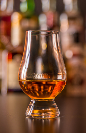 Scottish whisky in a glass with ice cubes, golden color whiskey, exclusive drinkの写真素材