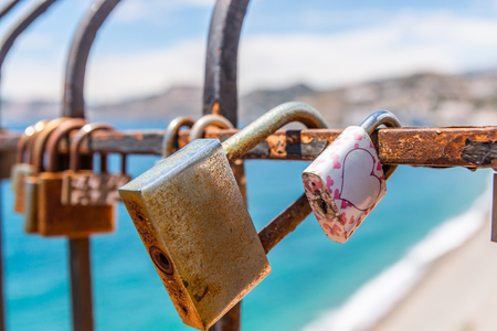 Rusty padlock attached to a balustrade by the sea, a traditional way of showing love, relationshipの写真素材