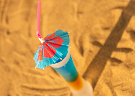 Colorful shots drinks on a sandy beach with umbrellas for drinks, summer relaxの写真素材