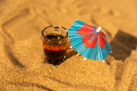 Colorful shots drinks on a sandy beach with umbrellas for drinks, summer relaxの写真素材