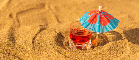 Colorful shots drinks on a sandy beach with umbrellas for drinks, summer relaxの写真素材