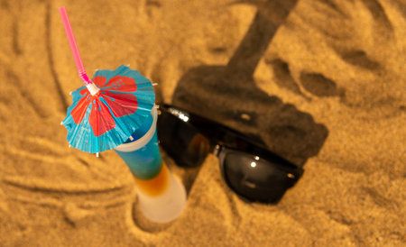 Colorful shots drinks on a sandy beach with umbrellas for drinks, summer relaxの写真素材