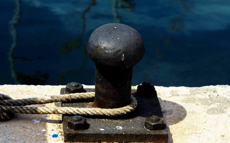 Mooring post on the waterfront in a small marina, element for mooring ships in the harbor, safety