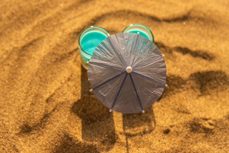 Colorful shots drinks on a sandy beach with umbrellas for drinks, summer relaxの写真素材