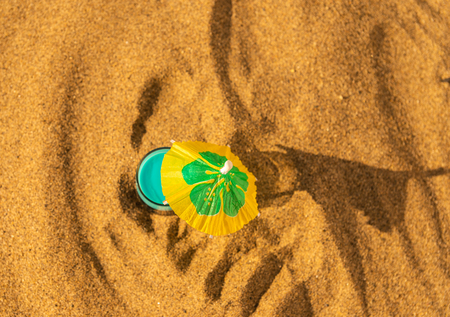 Colorful shots drinks on a sandy beach with umbrellas for drinks, summer relaxの写真素材