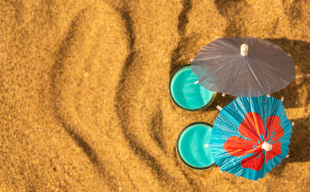 Colorful shots drinks on a sandy beach with umbrellas for drinks, summer relaxの写真素材