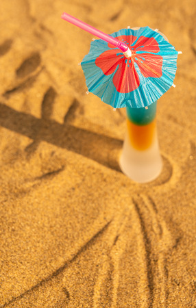 Colorful shots drinks on a sandy beach with umbrellas for drinks, summer relaxの写真素材