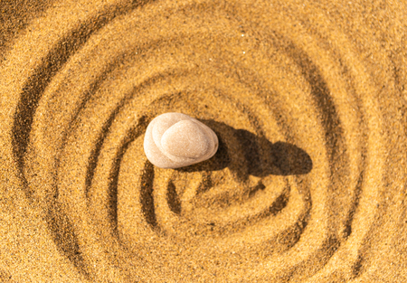 zen meditation stone in sand, concept for purity harmony and spirituality, spa wellness and yoga background, harmonyの写真素材