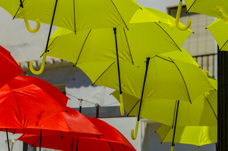 Colourful umbrellas urban street decoration. Hanging colorful umbrellas over blue sky, tourist attraction, sunny dayの写真素材