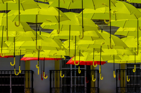 Colourful umbrellas urban street decoration. Hanging colorful umbrellas over blue sky, tourist attraction, sunny dayの写真素材