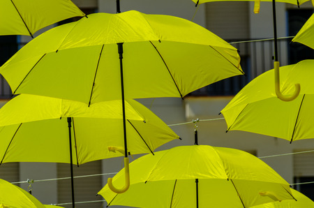 Colourful umbrellas urban street decoration. Hanging colorful umbrellas over blue sky, tourist attraction, sunny dayの写真素材