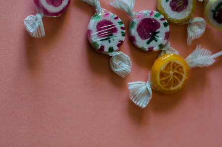 Colorful fruit lollipops on a pink background, unhealthy but delicious snack for children, sweetsの写真素材