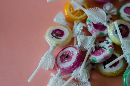 Colorful fruit lollipops on a pink background, unhealthy but delicious snack for children, sweetsの写真素材