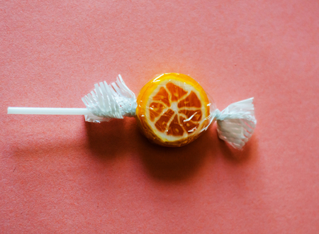 Colorful fruit lollipops on a pink background, unhealthy but delicious snack for children, sweetsの写真素材