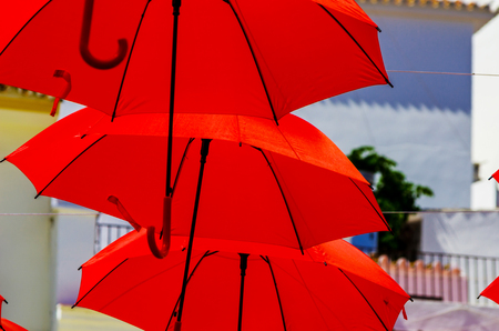 Colorful umbrellas urban street decoration. Hanging colorful umbrellas over blue sky, tourist attraction, sunny dayの写真素材