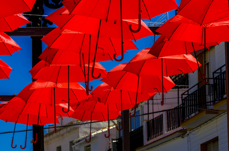 Colorful umbrellas urban street decoration. Hanging colorful umbrellas over blue sky, tourist attraction, sunny dayの写真素材