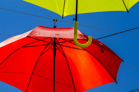 Colorful umbrellas urban street decoration. Hanging colorful umbrellas over blue sky, tourist...