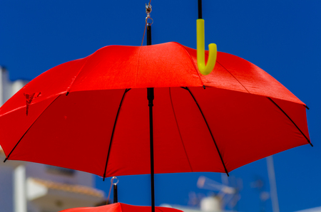 Colorful umbrellas urban street decoration. Hanging colorful umbrellas over blue sky, tourist attraction, sunny dayの写真素材