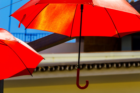Colorful umbrellas urban street decoration. Hanging colorful umbrellas over blue sky, tourist attraction, sunny dayの写真素材