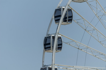 A big wheel in the seaside village, on a clear blue sky and sunny dayの写真素材