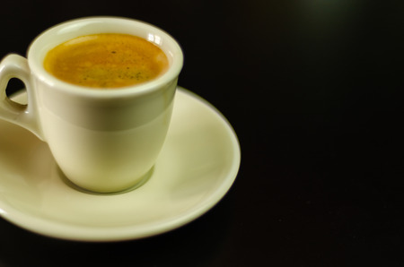 Black coffee in a ceramic cup on the bar, energy drink in a public place, cafe conceptの写真素材