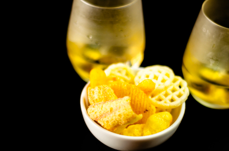 Glasses of whiskey with salty snacks on the background of the bar, party timeの写真素材