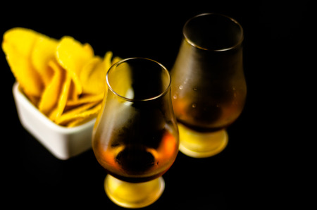 Glasses of whiskey with salty snacks on the background of the bar, party timeの写真素材