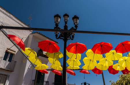Colourful umbrellas urban street decoration. Hanging colorful umbrellas over blue sky, tourist attraction, sunny dayの写真素材