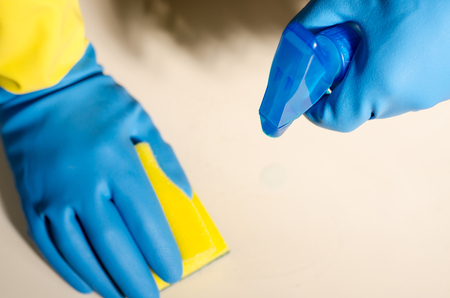 Hands in rubber gloves cleaning the surfaces of ceramic tiles, safe and hygienic cleaning, keeping the house cleanの写真素材