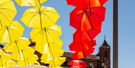 Colourful umbrellas urban street decoration. Hanging colorful umbrellas over blue sky, tourist attraction, sunny dayの写真素材