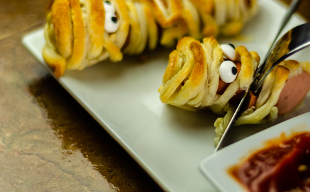 Sausage mummies in dough scary halloween food celebration party with funny eyes, food for kidsの写真素材