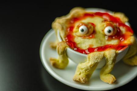 Cake baked in the shape of a monster in a ceramic bowl, sweet for Halloween, scary foodの写真素材