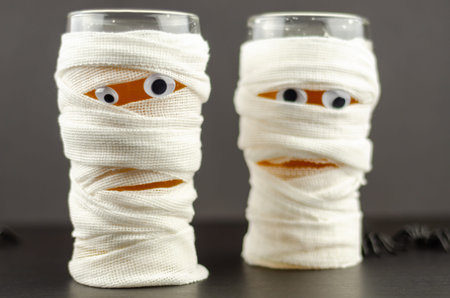 glass of beer decorated like an Egyptian mummy, a drink for a halloween party, scary beer