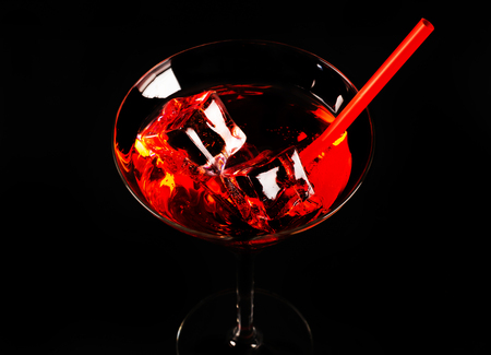 Red refreshing cocktail prepared by the bartender on a black background, party nightの写真素材